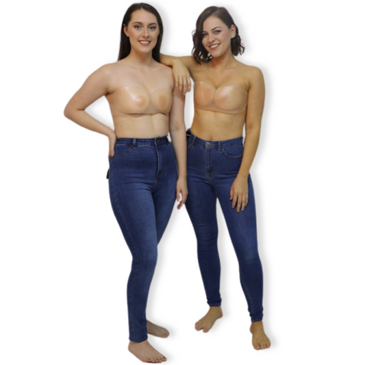 Two women wearing jeans, wearing Nude NIPPLE COVERS and translucent STRAP'EM SISTER products